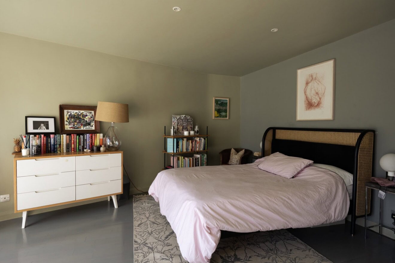 Bright, stylish bedroom featuring a large bed, bookshelves, and contemporary furnishings.