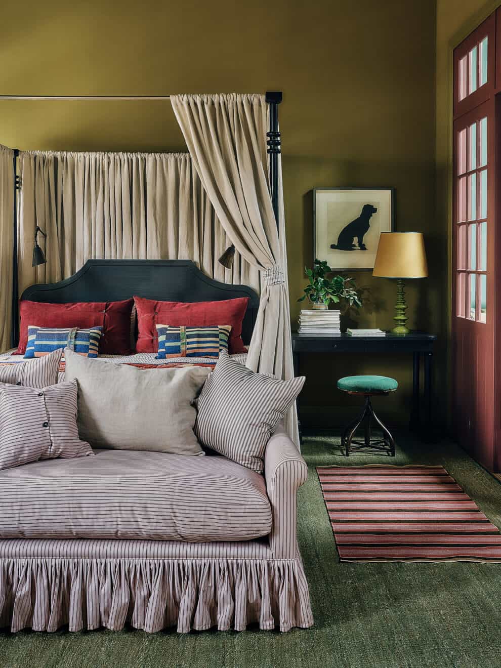 Elegant bedroom featuring a canopy bed, striped sofa, and vintage-style decor.