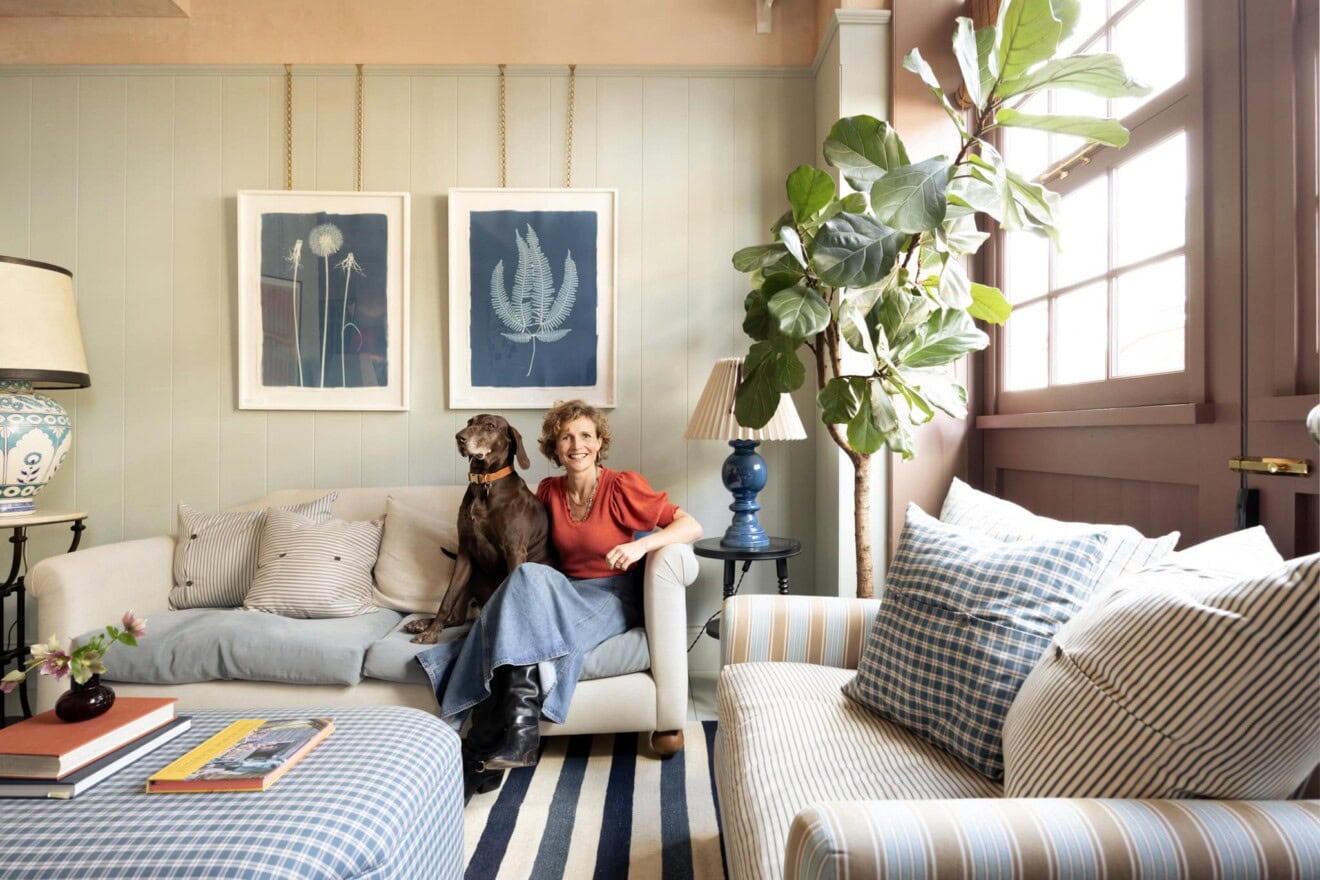 Bright living room featuring woman with dog, stylish furniture, and large window.