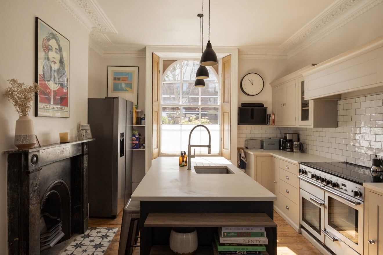 Bright kitchen with white cabinets, large window, and modern appliances.